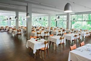 una sala da pranzo con tavoli e sedie bianchi di Terme di Acquasanta Hotel Italia & Spa ad Acquasanta Terme