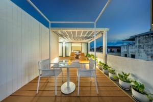 a dining table and chairs on a balcony at The Lair Bangkok - 3mins walk to ICON SIAM in Bangkok