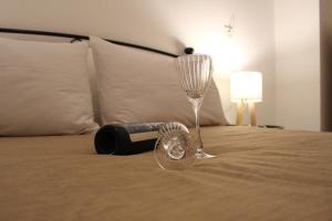 a bottle of wine and a wine glass on a bed at Fay's Apartments II in Arachova