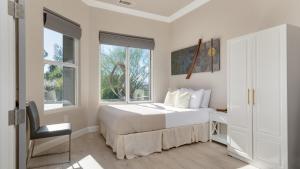 a bedroom with a bed and a desk and windows at Summit Ranch by AvantStay Infinity Pool Views in Temecula +41 photos