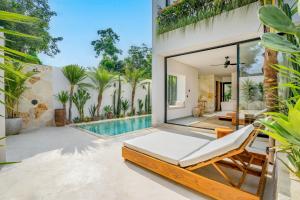 eine Außenterrasse mit einem Bett und einem Pool in der Unterkunft Modern Villa with Pool - Lago Villas in Bingin Beach