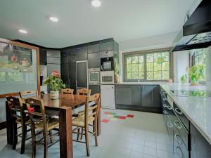 eine Küche mit einem Holztisch und Stühlen darin in der Unterkunft Splendid house next to the Baqueira Beret ski resort in Vielha e Mijaran