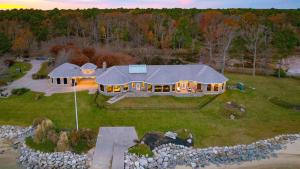 une vue aérienne d'une grande maison avec des lumières dans l'établissement Bay Estate by AvantStay Waterfront Private Pond, à Ridge