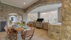 une cuisine avec une table et des chaises et un mur en pierre dans l'établissement Bay Estate by AvantStay Waterfront Private Pond, à Ridge