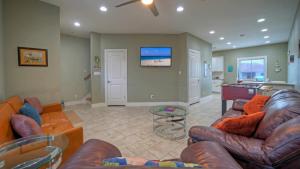 ein Wohnzimmer mit Sofas und einem Tisch sowie eine Küche in der Unterkunft Ridley Retreat Community Pool Mins to the Beach Corpus Christi Port A in Padre Island