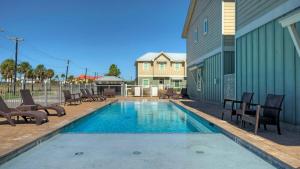 ein Swimmingpool mit Stühlen und ein Haus in der Unterkunft Ridley Retreat Community Pool Mins to the Beach Corpus Christi Port A in Padre Island
