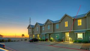 ein Gebäude mit einem auf einem Parkplatz geparkten Auto in der Unterkunft Ridley Retreat Community Pool Mins to the Beach Corpus Christi Port A in Padre Island