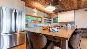 cocina con nevera de acero inoxidable y techo de madera en Modern Catskills Escape w Open Living Steam Shower Hot Tub w Mountain Views Minutes from Woodstock Trails Suncliff Vista, en Shokan