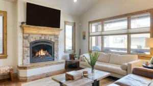 a living room with a couch and a fireplace at Blue Skies Lakeside Family-Friendly Getaway w Hot Tub BBQ in Heber City