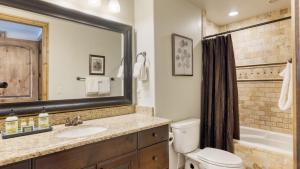 a bathroom with a sink and a toilet and a mirror at Blue Skies Lakeside Family-Friendly Getaway w Hot Tub BBQ in Heber City +24 photos