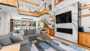 a living room with a gray couch and a tv at The Grand on Greenbay-7 bedrooms Sleeps 20 Modern new build in Mooresville