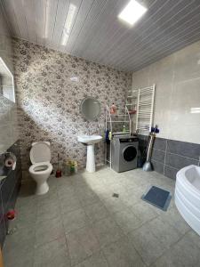 a bathroom with a toilet and a sink and a sink at Happy Rustavi guest house in Rustavi