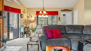 ein Wohnzimmer mit einem Sofa und roten Kissen in der Unterkunft Atlas Point Lodge Sauna Fireplaces Kayaks Lakes Pet-Friendly Yard in Pocono Lake