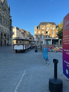a trolley car on a street in a city at Mezzanine Studio Hyper Centre in Saint-Quentin +3 photos