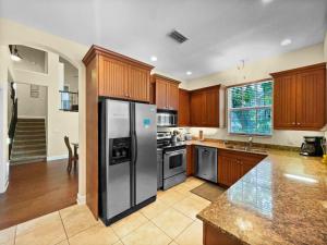 a kitchen with wooden cabinets and a stainless steel refrigerator at Avenida De Cortez in Bailey Hall +24 photos