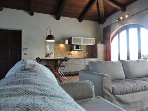 sala de estar con sofá y cocina en Cascina Volpona, en Case Bruciate