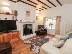 a living room with a white couch and a television at Minn's Cottage in Snainton