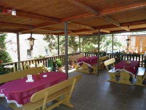 a restaurant with purple tables and chairs on a deck at Pension Sonja Müller in Nohra