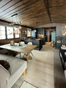 Una sala de estar con una mesa y una cocina. en Modern Mountain Cabin With Views Over Slokovannet, en Haglebu