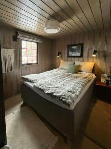 Un dormitorio con una cama grande con techo de madera. en Modern Mountain Cabin With Views Over Slokovannet, en Haglebu
