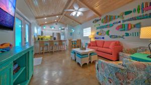 a living room with a red couch and a table at Sleeps 18 2 Beach Homes w 2 Pools Playground Covered Patios Pirates Bay by AvantStay in Mustang Beach