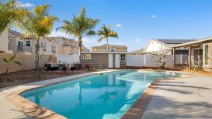 a swimming pool in the backyard of a house with palm trees at California Dreamin by AvantStay Private Pool Fire Pit Near the Beach in Carlsbad