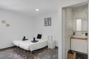 a white bedroom with a bed and a sink at Casa sofia in Argana