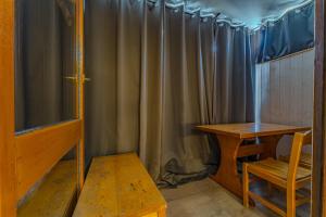 a table and a bench in a room with a curtain at Hauts de Vanoise 3 personnes Coeur Village in Val Thorens