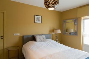 a bedroom with a bed and two tables and a mirror at Abeellogies in Tielt