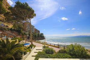 a walkway next to a beach with the ocean at PLAYAMERO Apartments in Salou