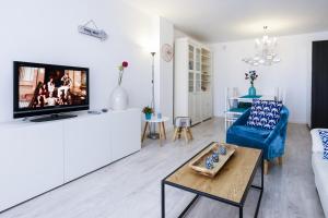 a living room with a couch and a tv at PLAYAMERO Apartments in Salou