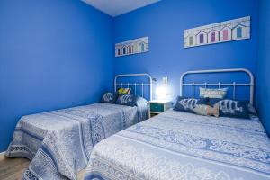two beds in a room with blue walls at PLAYAMERO Apartments in Salou +30 photos
