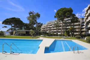 a swimming pool in front of a apartment building at PLAYAMERO Apartments in Salou