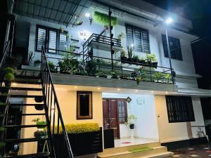 a house with a balcony with plants on it at Garden view home stay for family near meitra hospital in Kozhikode