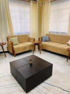 a living room with two couches and a coffee table at Boma Hill Residence Apartments by Monalisa in Morogoro