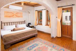 een slaapkamer met een bed, een raam en een deur bij Aja Cappadocia Cave Hotel in Urgup +45 foto's