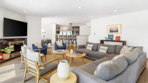 Una sala de estar con un sofá y sillas y un televisor. en Edendale by AvantStay Urban Hilltop Oasis w Amazing Views in 3 of Los Feliz, en Los Ángeles