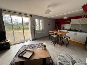 a living room with a table and a kitchen at Gîte dans un petit haras in Mézidon +62 photos