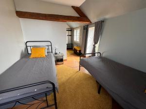 a bedroom with two beds in a room at Gîte dans un petit haras in Mézidon