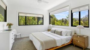 a white bedroom with a bed and two windows at Edendale by AvantStay Urban Hilltop Oasis w Amazing Views in 3 of Los Feliz in Los Angeles