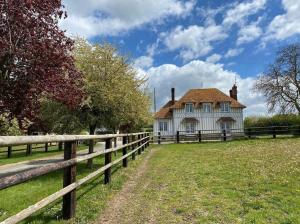 an old house with a fence in front of it at Gîte dans un petit haras in Mézidon