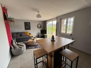 a living room with a table and a couch at Gîte dans un petit haras in Mézidon