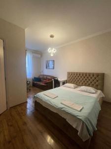 a bedroom with a large bed and a couch at Happy Rustavi guest house in Rustavi