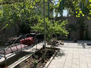 a garden with a bench and a table and trees at Happy Rustavi guest house in Rustavi +32 photos