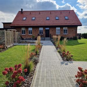 a brick house with a walkway in front of a yard at Stara Szkola - Wielki Medromierz 59 in Wielki Modromierz