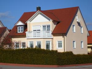a white house with a red roof at FeWoAngela in Maxhütte-Haidhof