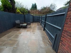 a patio with a fence and a table and chairs at 2 Bed House - Sleeps 6 - Parking - Wifi in Oldbury