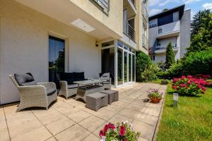 eine Terrasse mit Stühlen, einem Tisch und Blumen in der Unterkunft Hotel ANTARES in Bratislava