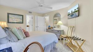 a bedroom with a bed and a desk and a chair at 123D Shipwatch by AvantStay Beach Access Pool in Isle of Palms