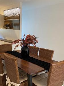 a dining room table with a vase of flowers on it at Deluxe Apartment Nähe Festspielhaus mit Tiefgaragenstellplatz in Baden-Baden +22 photos